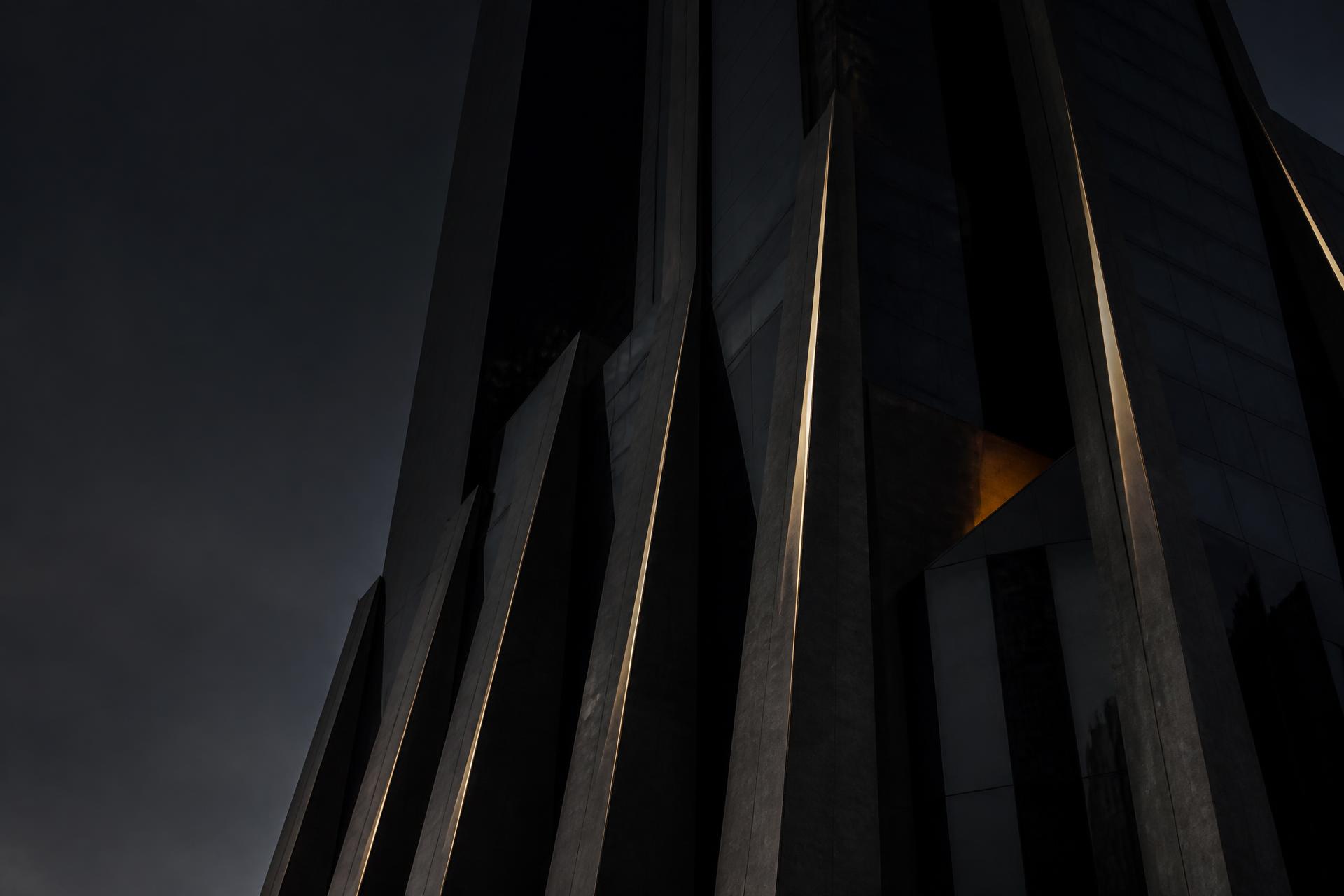 Dark architectural facade of a Dubai tower at dusk